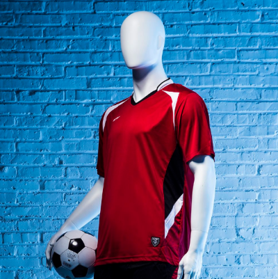 サッカーボールを持つ男性マネキン斜め前ビュー|赤と黒のユニフォーム・青壁背景