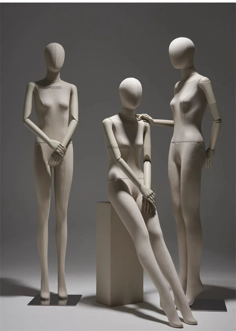 リネン布張りと木製腕の女性マネキン3体展示例|ナチュラルベージュカラー・立ちポーズと座りポーズのディスプレイ