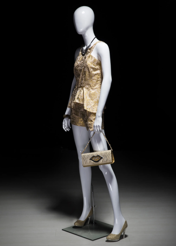 女性マネキンの斜め前ビュー|ゴールド衣装とバッグを持つディスプレイ例