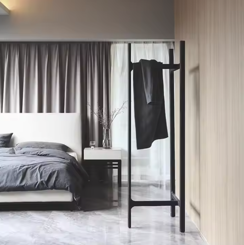 ベッドルームで使用されるブラックハンガースタンド|ミニマルデザインの衣類掛けフレーム