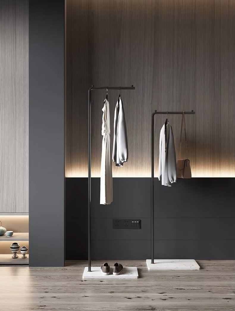 ブラックとホワイトのスタンドハンガーラックに衣類を掛けたスタイリッシュな室内インテリア