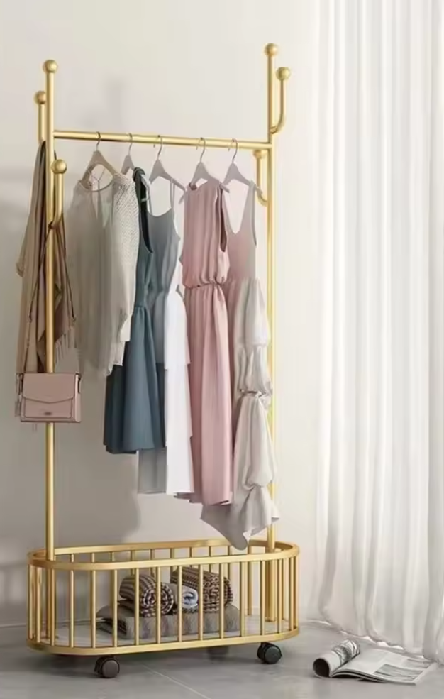 ゴールドフレームのハンガーラックにワンピースを掛けたシンプルな収納ディスプレイ