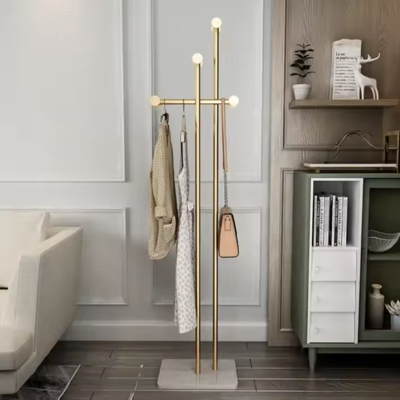 ゴールドスタンドコートハンガーにストールとバッグを掛けたエレガントな室内ディスプレイ