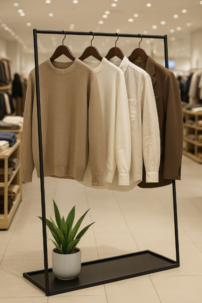 ニュートラルカラーの洋服を掛けたブラックハンガーラックと観葉植物の組み合わせ|温かみのある室内ディスプレイ例