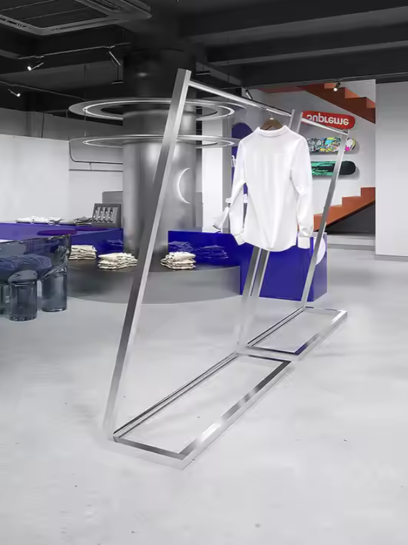 シルバーフレームの大型ハンガーラックに衣類を掛けたショップディスプレイ