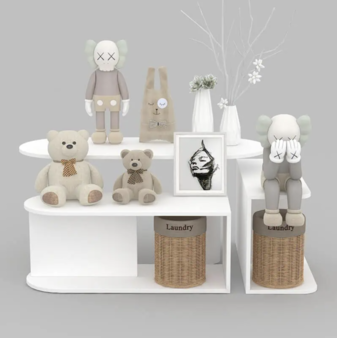 ホワイトカラーのディスプレイステージにぬいぐるみやアートオブジェを展示したキッズ向け店舗ディスプレイ什器
