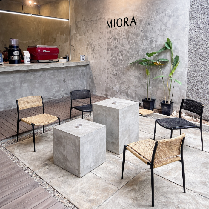 ソファ横に配置されたダークグレーのハイ展示台とブラックベースのランプ