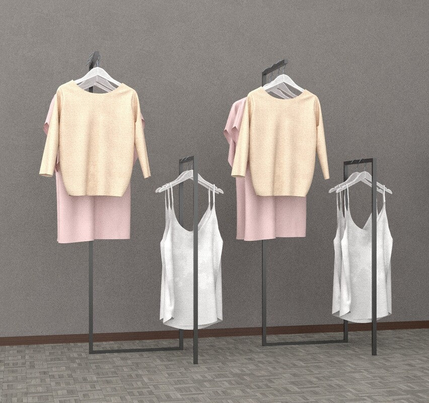 ブラックフレームのハンガーラックに淡色トップスを掛けた室内ディスプレイ