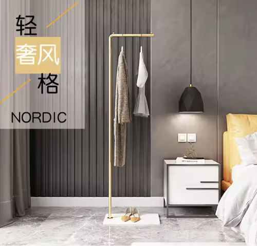 ゴールドスタンドハンガーに衣類を掛けた北欧風ベッドルームインテリアディスプレイ