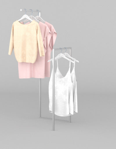 シルバーフレームのハンガーラックに淡色の衣類を掛けたミニマルな商品ディスプレイ
