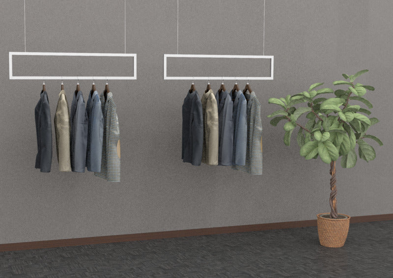 壁掛け式ハンガーバーに衣類を掛け、観葉植物を配置した室内ディスプレイ