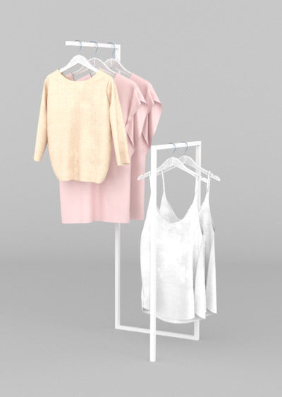 ホワイトフレームのハンガーラックに淡色トップスを掛けたシンプルな展示ディスプレイ